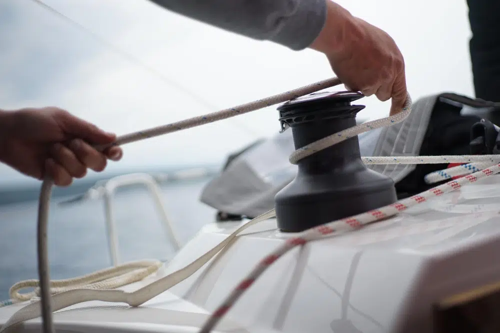 Crew member handling ropes on a yacht deck